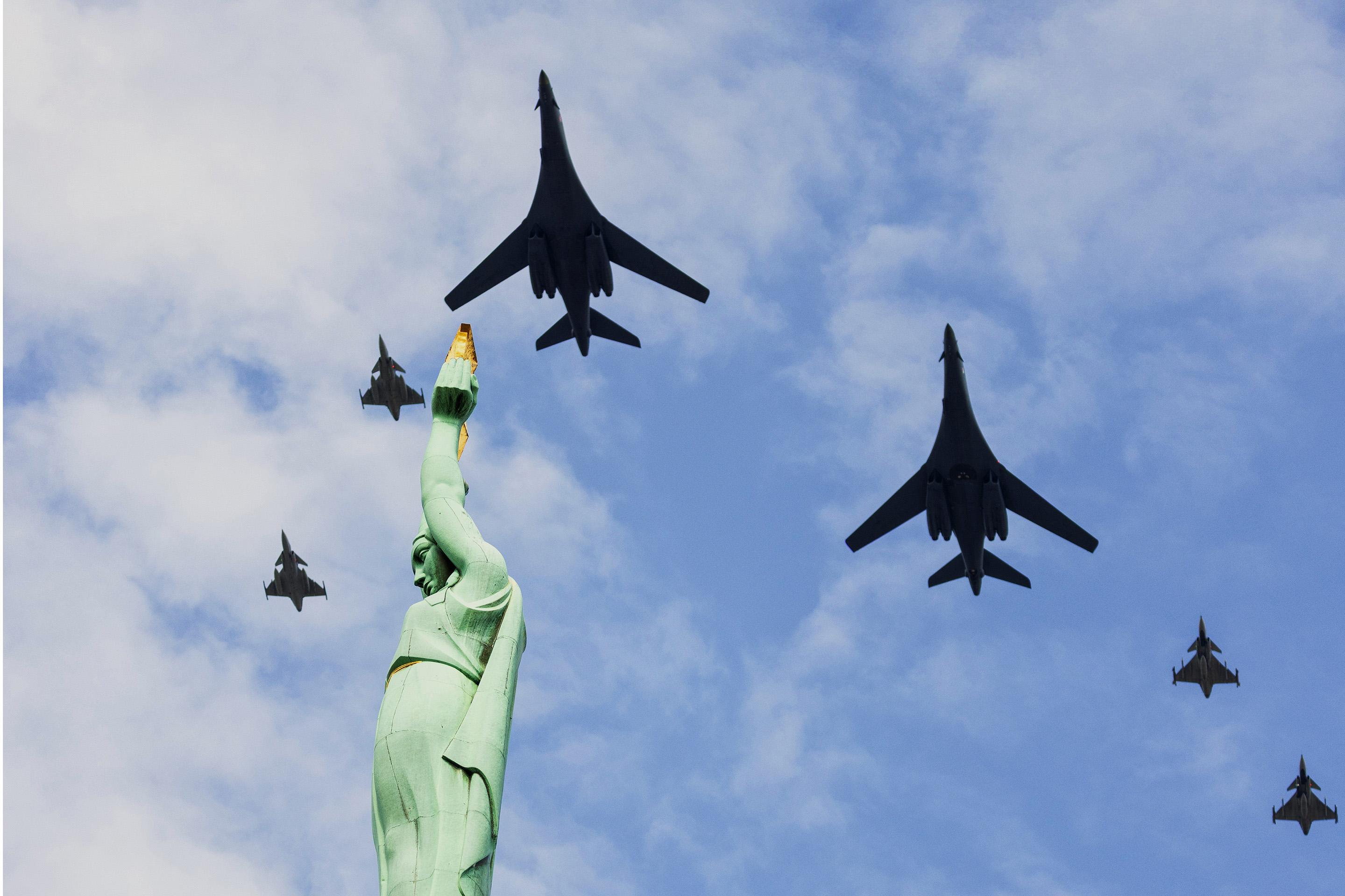 Air Force B-1B Lancer aircraft flies in formation alongside NATO Allied fighter jets over Monument of Freedom in Riga, Latvia, during Bomber Task Force Europe exercise, August 19, 2025 (NATO)